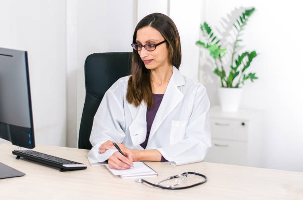 istock Elegant woman doctor taking notes from the computer 1125845034