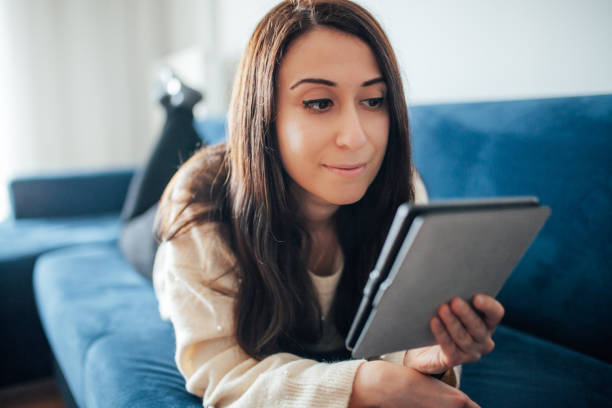 istock Woman reading e book at home 1125846822