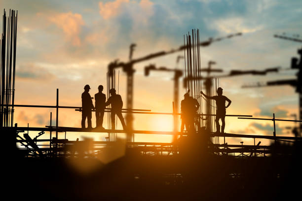 istock Silhouette of engineer and construction team working at site over blurred background for industry background with Light fair.Create from multiple reference images together 1125849375