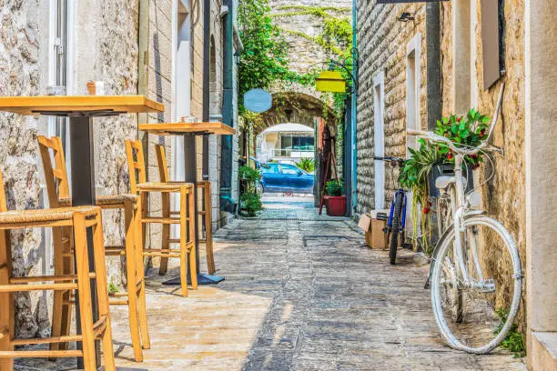 Photo of Old Town  Budva, Montenegro. The first mention of this city - more than 26 centuries ago. We see ancient houses, a very narrow street, cafes, shops.