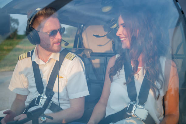 istock Pilot and female passenger with fastened seat belts sitting in helicopter cockpit 1125851296