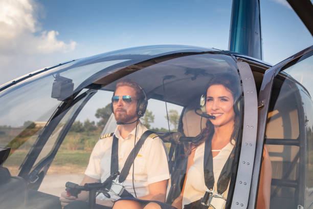 istock Female passenger with headset in helicopter cockpit with pilot 1125851299