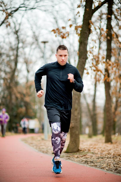 istock Young athletic man jogging on sports track 1125853966