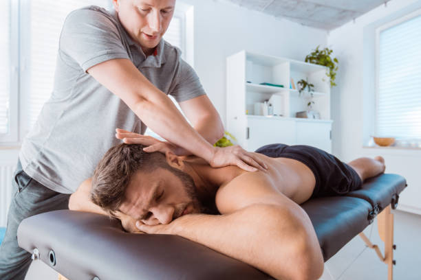 rückseite des jungen mannes massieren massage-therapeut - human spine chiropractic adjustment backache human bone stock-fotos und bilder