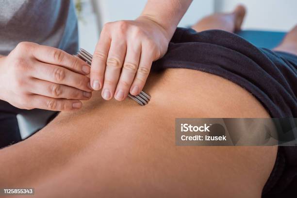 Physiotherapist Massaging Mens Back Using Tools Stock Photo - Download Image Now - Adult, Adults Only, Alternative Therapy