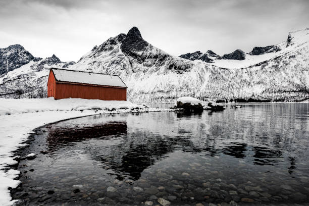 冬の間にノルウェー北部のセニ�ヤ島島に劇的な冬の風景を流すノルウェー赤 - snow horizon winter shed ストックフォトと画像