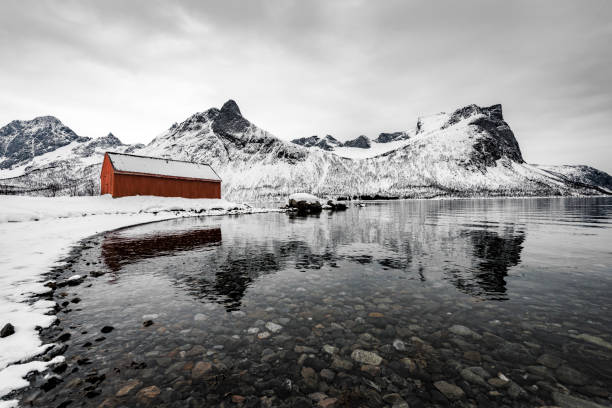 冬の間にノルウェー北部のセニヤ島島に劇的な冬の風景を流すノルウェー赤 - snow horizon winter shed ストックフォトと画像