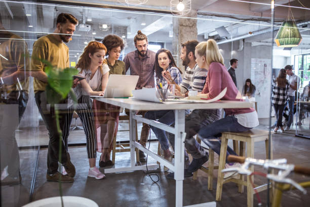 istock Large group of multi-tasking freelance workers at casual office. 1125858023