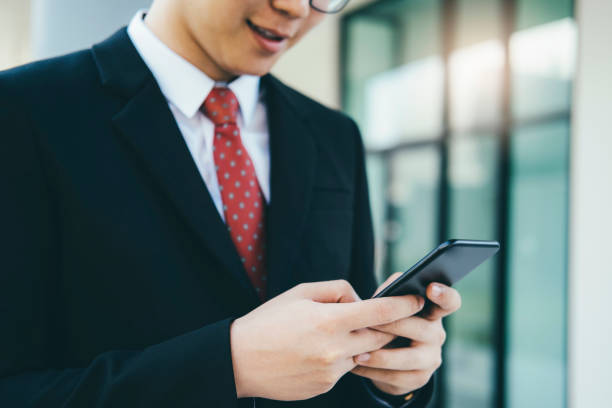 istock businessman using mobilephone app texting outside of office. 1125858062