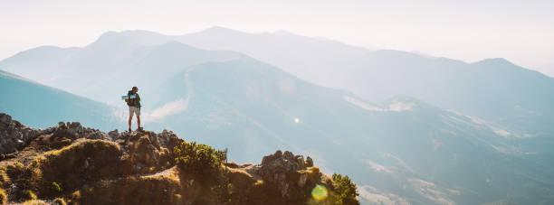 istock Mountain hiker with backpack tiny figurine stay on mountain peak with beautiful panorama 1125861761