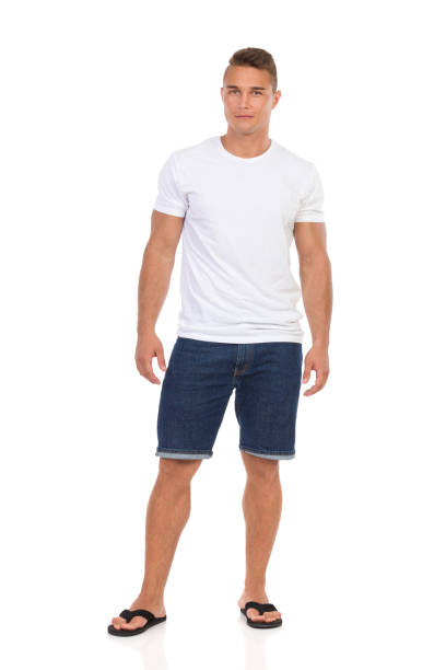 legerer mann im weißen t-shirt und jeans-shorts, blick in die kamera - shorts stock-fotos und bilder