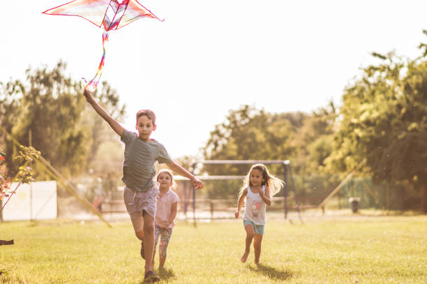 istock Kids running with kite in nature 1125862813