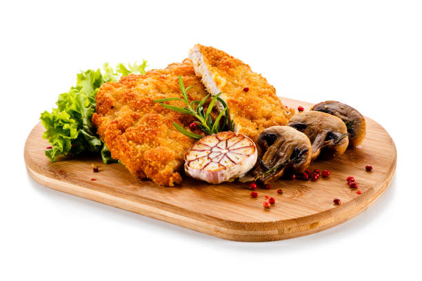 Fried pork chop with champignon and vegetable salad on white background