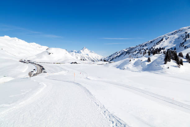Winter wonderland scenery with a road and ski resort in a valley covered with snow in Austrian Alps, a lot of copy space.