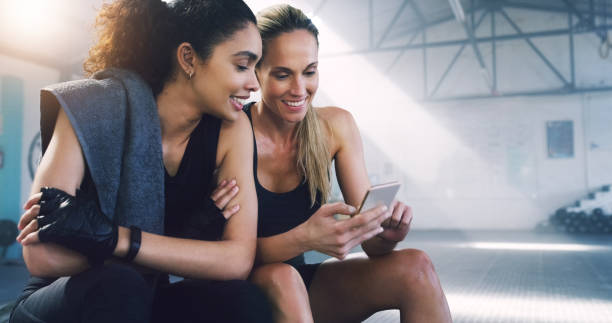 al passo con le ultime novità, ovunque e in qualsiasi momento - friendship women exercising gym foto e immagini stock