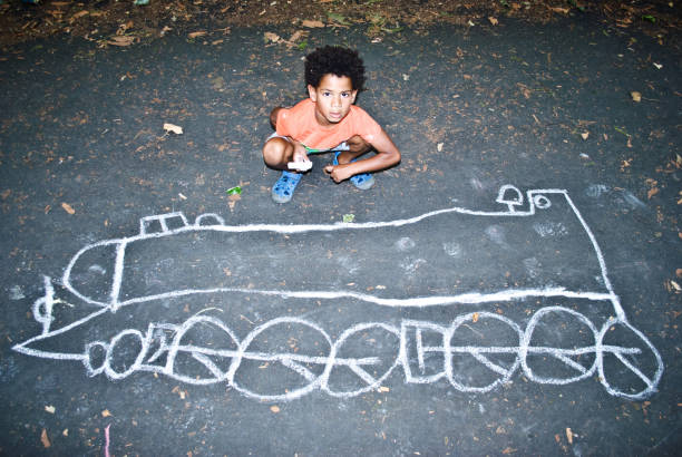 Child playing outdoors - drawing on the ground