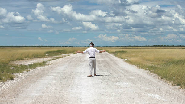 istock Man opening arms savannah road. Exploring virtual reality 1125869014
