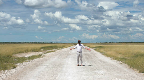 istock Man opening arms savannah road. Exploring virtual reality 1125869035