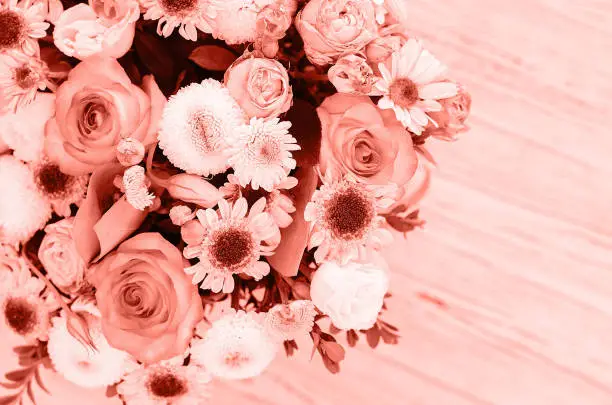 Photo of Flower arrangement in a box of fashionable coral color.