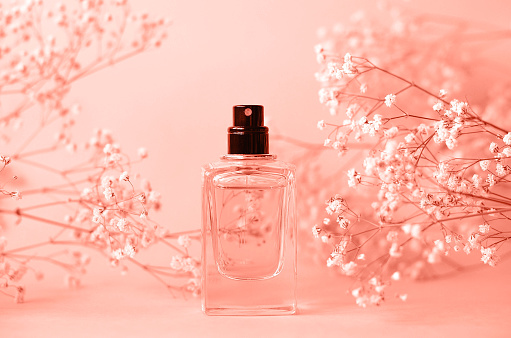 A product on display in a colorful studio environment. The beauty product on display is a glass perfume bottle with a luxury feeling. Created in 3D.