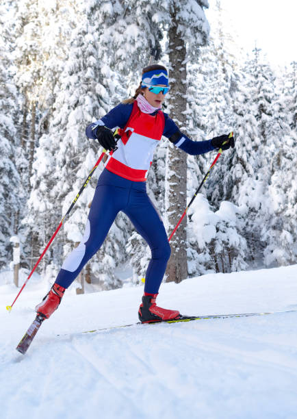 vorderansicht des weiblichen biathlon konkurrent üben langlauf - biathlon stock-fotos und bilder