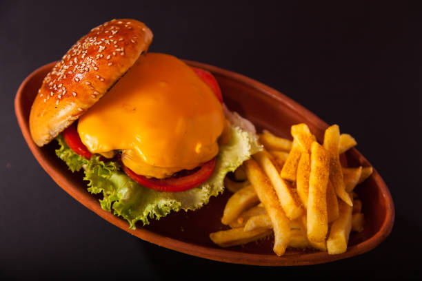 istock Burger and fries on casserole on dark  background 1125871011