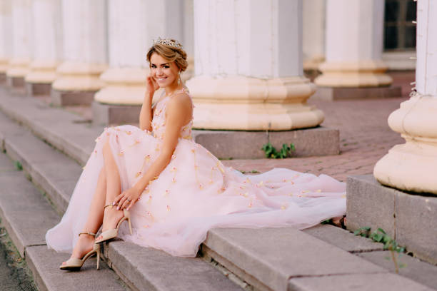 happy bride sits on steps near columns