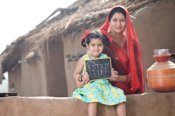 Photo of Mother with her daughter holding slate at village