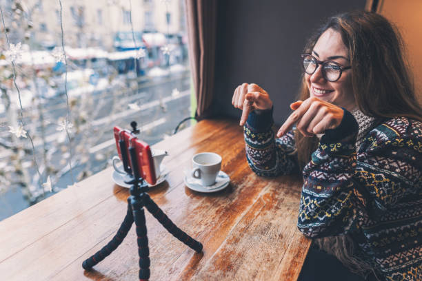 gelukkig jonge vrouw vlogging in het café - cafe snow stockfoto's en -beelden