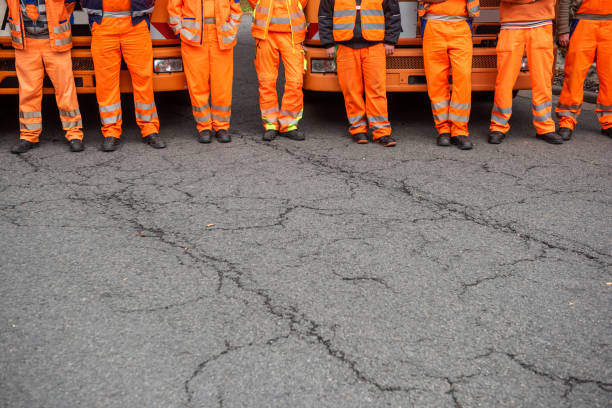 conductores de camiones de basura de pie delante de sus vehículos, alemania - orange uniform fotografías e imágenes de stock