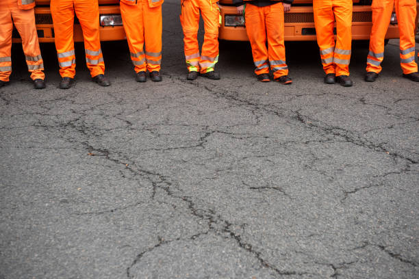 istock Garbage truck drivers standing in front of their vehicles, Germany 1125874787