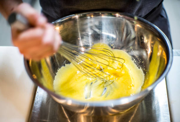 istock Chef is preparing a yellow sauce. Beats, pours, mixes. Kitchen in the restaurant. 1125874979