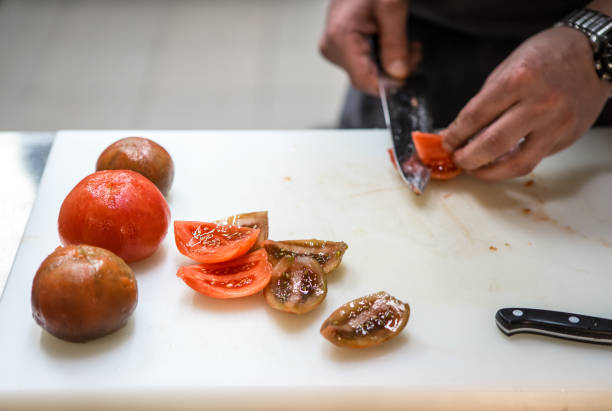 istock Cutting tomatoes with a kitchen knife. Chef. A restaurant. 1125875375