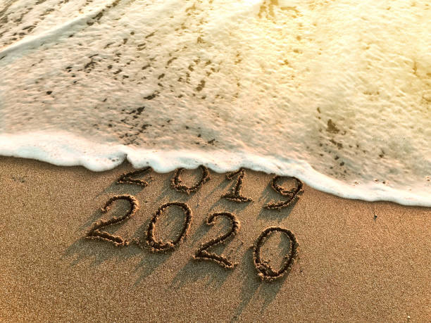 New year 2020 New year 2020 and old year 2019 written on sandy beach with waves new year 2019 stock pictures, royalty-free photos & images
