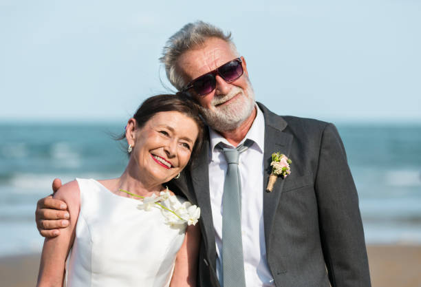 Senior couple getting married at the beach Senior couple getting married at the beach wedding dress photos stock pictures, royalty-free photos & images