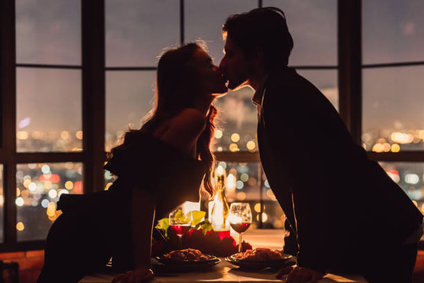 Romantic place for romantic evening concept Loving couple kissing on panoramic window background overlooking nigth city. Romantic place for romantic evening concept romantic activity stock pictures, royalty-free photos & images