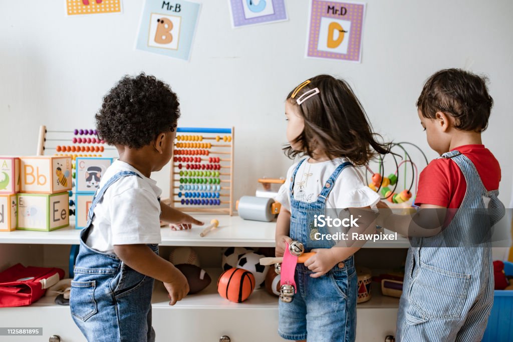 Jeunes enfants jouant avec des jouets éducatifs - Photo de Maternelle libre de droits