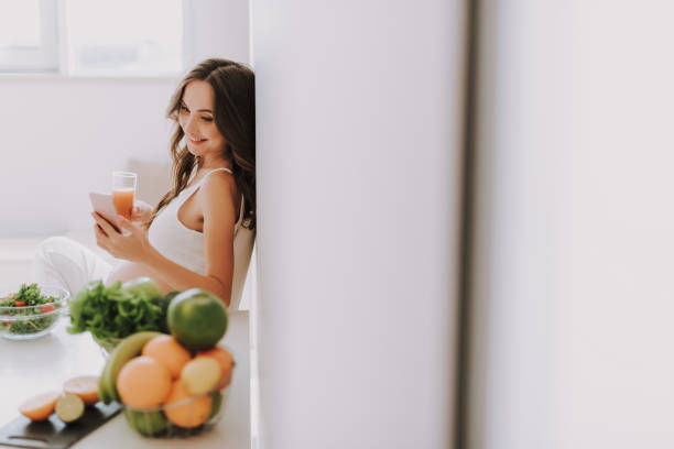 istock Beautiful young mama looking at cellular and drinking juice 1125882006