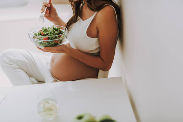 istock Hungry expectant mother is eating fresh salad 1125882012