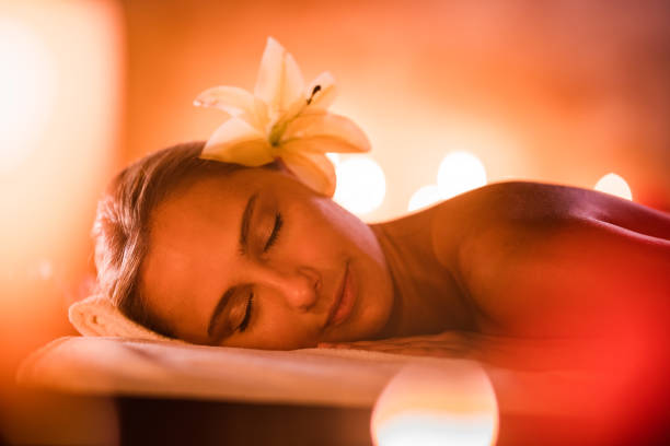 Young smiling woman enjoying the back massage in a professional massage salon.