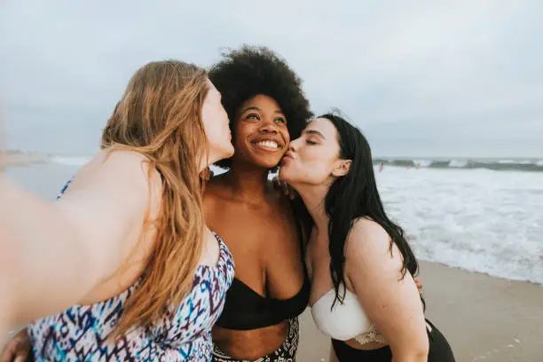 Photo of Beautiful curvy women taking a selfie at the beach