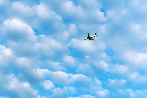 istock plane in the sky, white clouds in the blue sky 1125885953