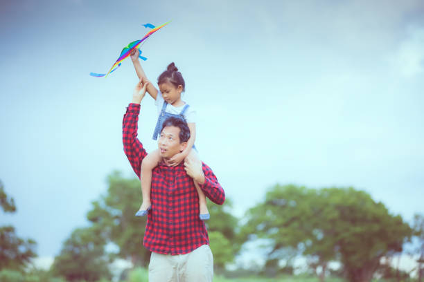 istock Father Carrying Daughter On Shoulder Against Sky 1125886094