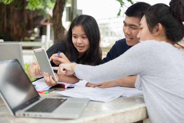 istock Friends Discussing Over Digital Tablet While Sitting Outdoors 1125887113