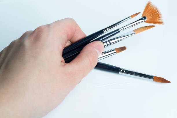 istock The hand holding the brush on a white background. 1125887137