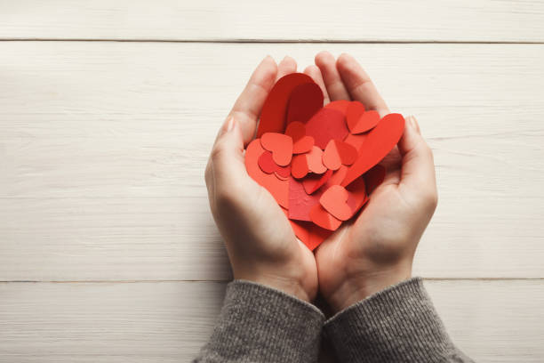 istock Valentine day background, hearts in female hands 1125888496