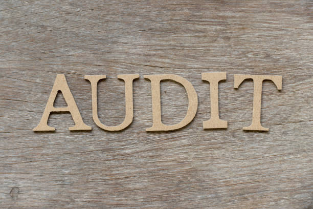 istock Alphabet letter in word audit on wood background 1125892440