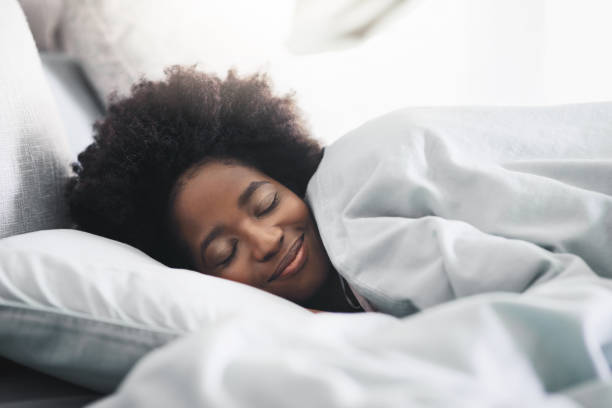 Sleep solves everything Shot of an attractive young woman sleeping in her bed in the morning at home sleeping stock pictures, royalty-free photos & images