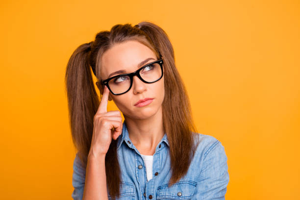 Close up photo of attractive amazing brunette she her lady prett Close up photo of attractive amazing brunette she her lady pretty hairstyle in specs thinking imagination flight wearing casual jeans denim shirt outfit isolated on yellow background deep pick stock pictures, royalty-free photos & images