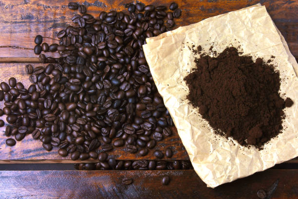 istock roasted coffee beans and ground coffee on paper over rustic table. Top view 1125896120